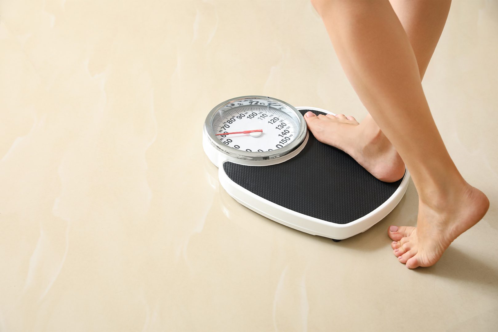 Woman stepping on floor scales